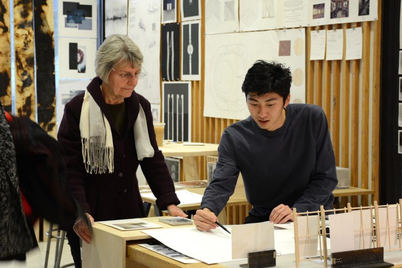 Student showing drawing to professor. 
