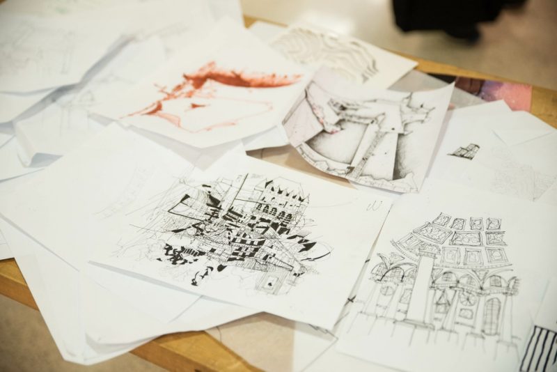 Lots of drawings together on a table.