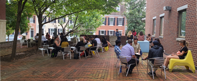 Students seated in discussion groups outside in the WAAC courtyard