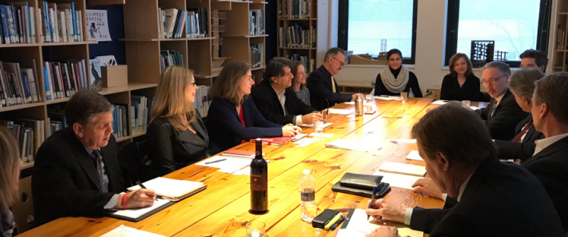 Members of the Firm Advisory Board seated around a conference table built of reclaimed wooden beams, in the WAAC library Secret Room